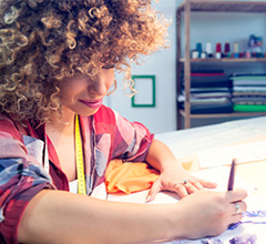 Stilista donna che disegna su un piano di lavoro